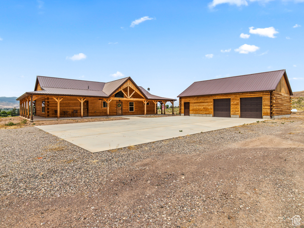 View of front of home featuring a garage and an outbuilding