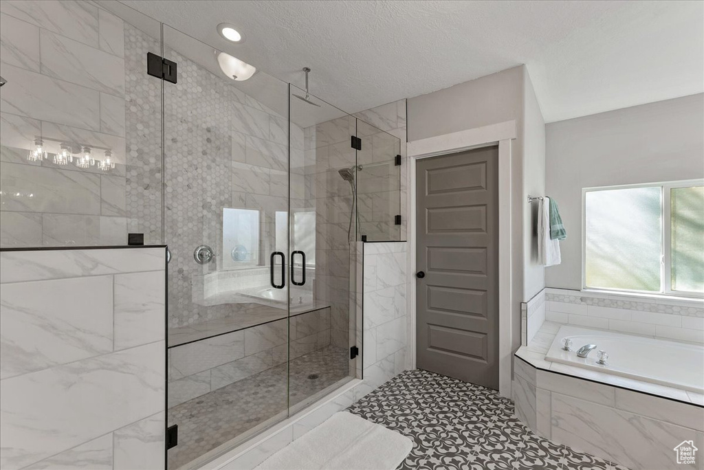 Bathroom featuring independent shower and bath and tile patterned flooring