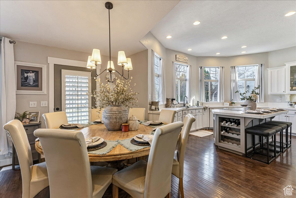 Dining room featuring sink, an inviting chandelier, and dark hardwood / wood-style floors