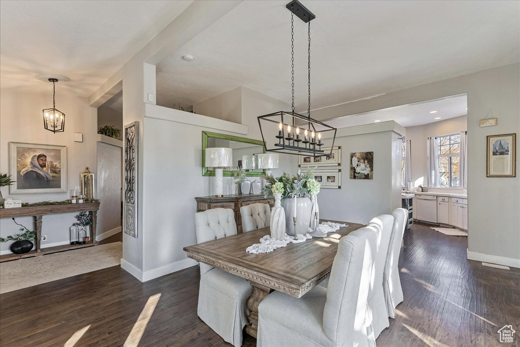 Dining room with dark hardwood / wood-style floors and a notable chandelier