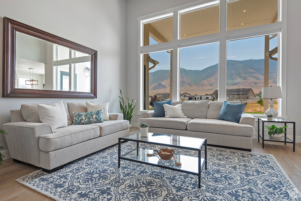 Living room with a mountain view, hardwood / wood-style floors, and a high ceiling