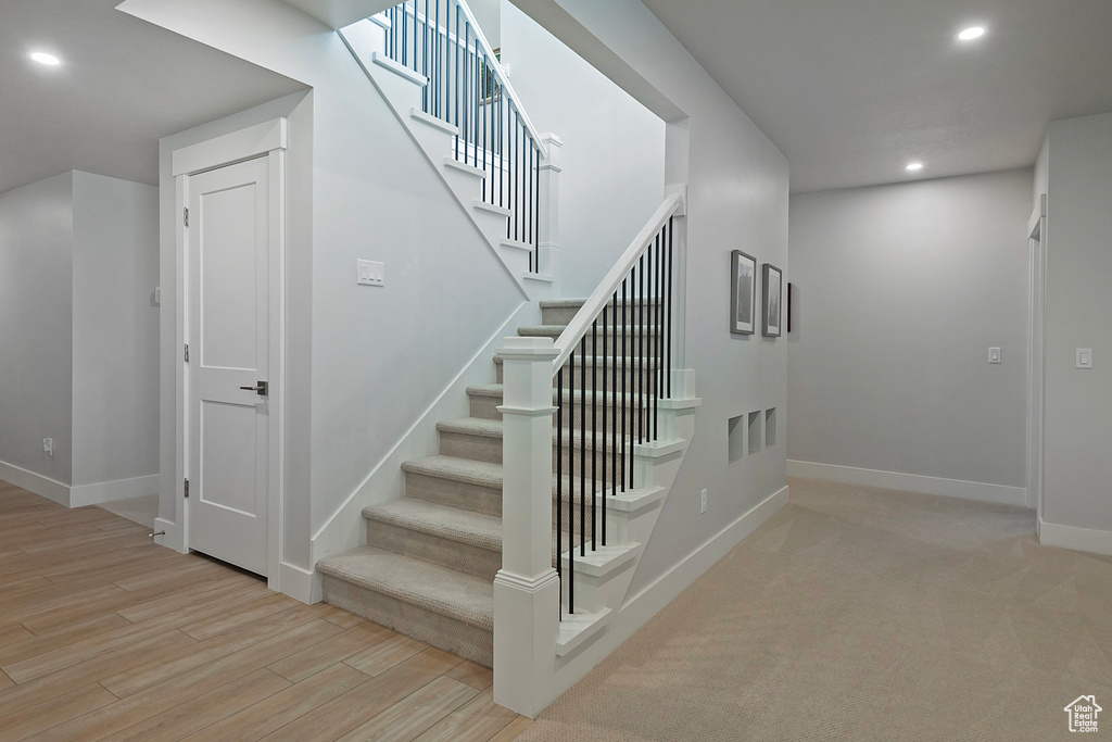 Stairway featuring light wood-type flooring