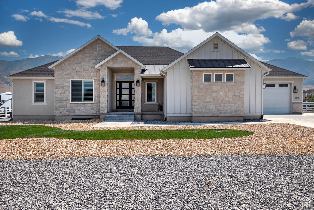 View of front of property with a garage and a mountain view