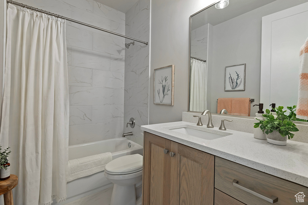 Full bathroom with vanity, shower / bathtub combination with curtain, and toilet