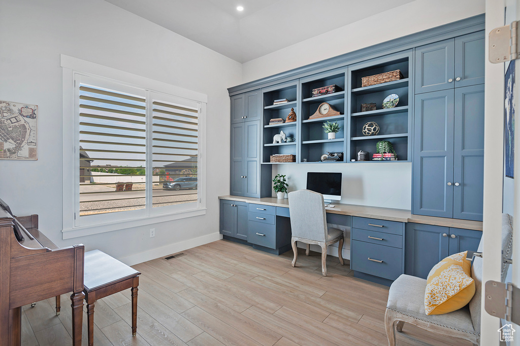 Home office featuring light hardwood / wood-style flooring and built in desk