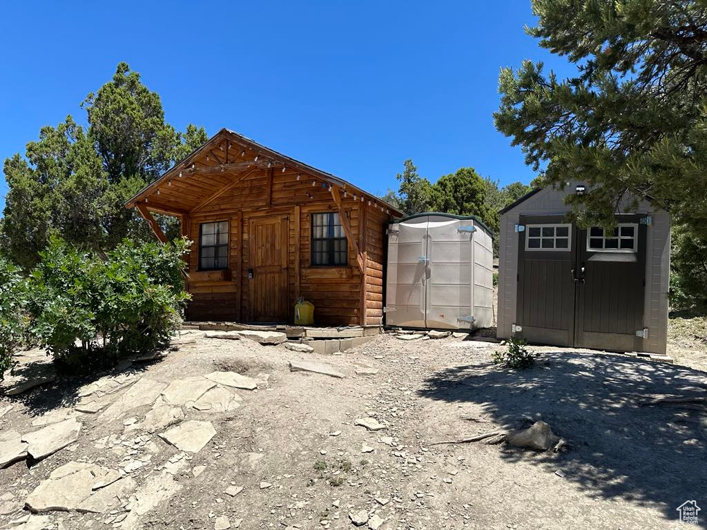 View of front of home featuring a storage shed