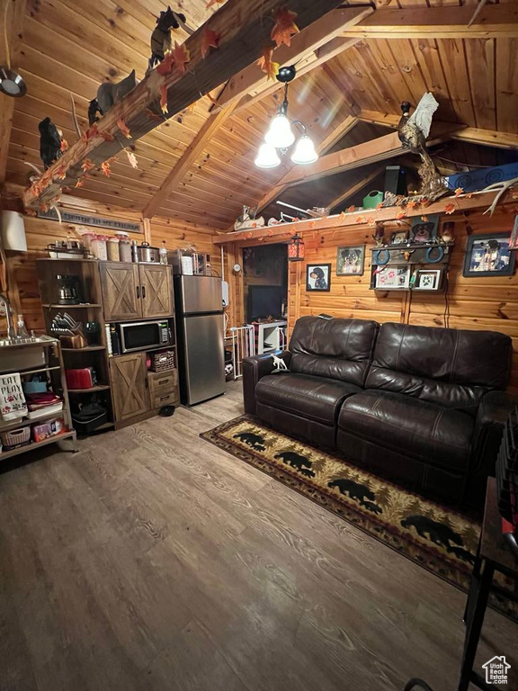 Living room with vaulted ceiling with beams, wood ceiling, wooden walls, and wood-type flooring