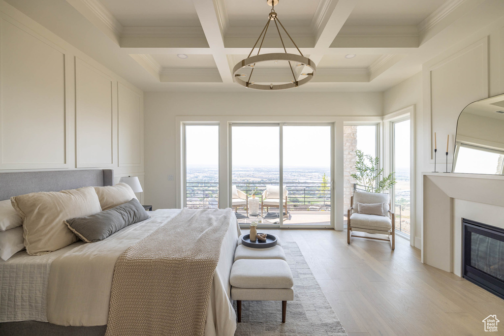 Bedroom with access to exterior, multiple windows, light wood-type flooring, and coffered ceiling