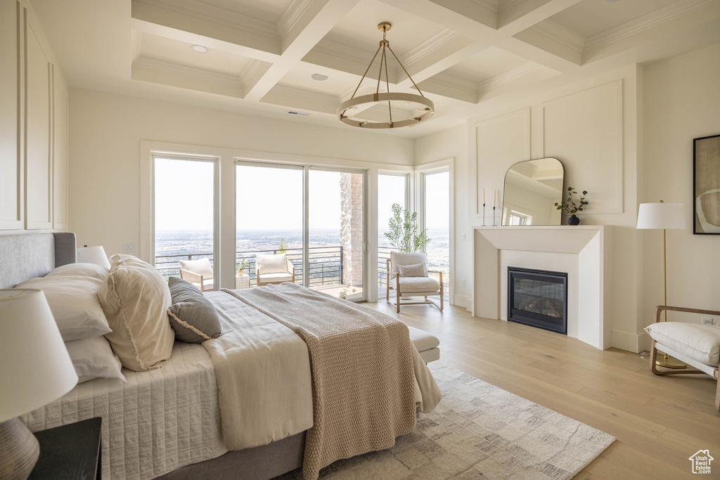 Bedroom with beam ceiling, light hardwood / wood-style flooring, coffered ceiling, and crown molding