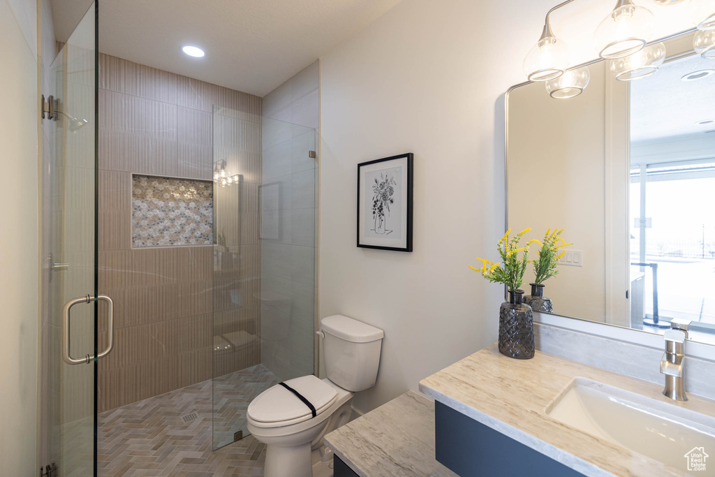 Bathroom featuring walk in shower, toilet, vanity, and parquet floors