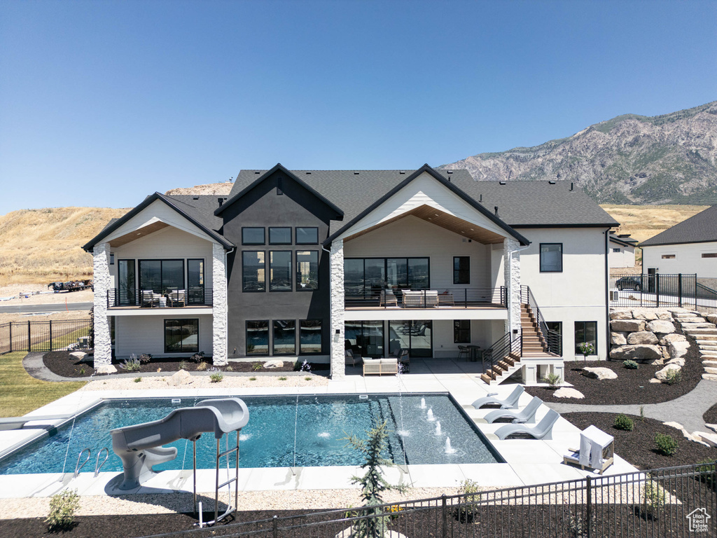 Back of house featuring a mountain view, a patio, and a fenced in pool