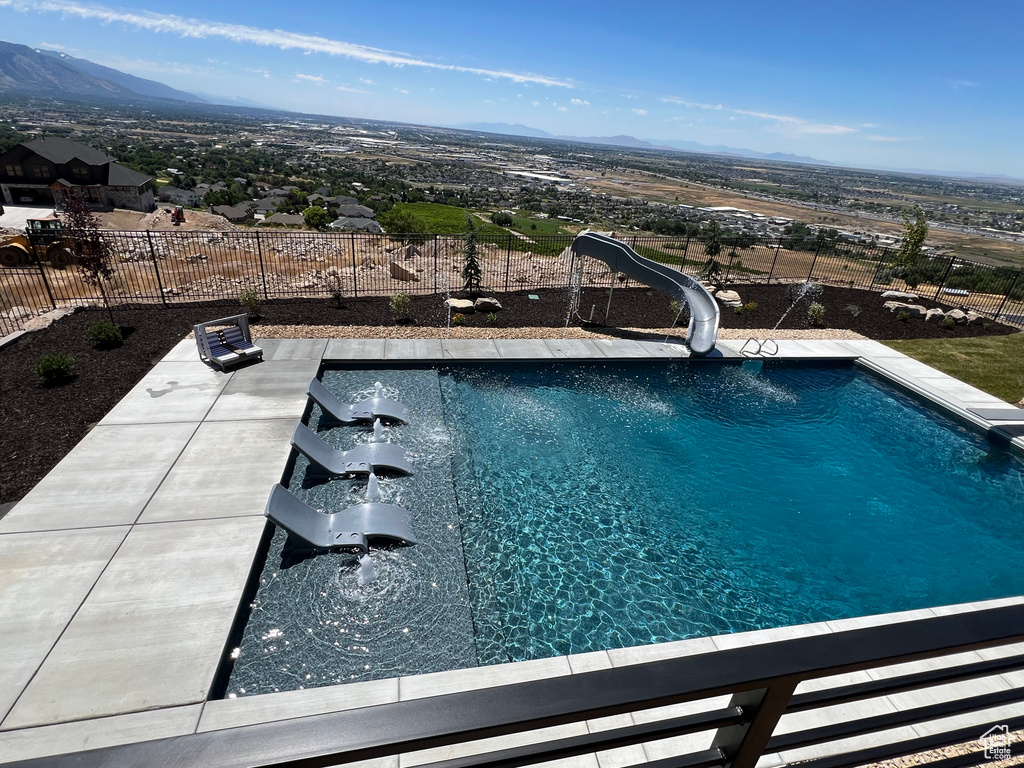 View of swimming pool with a mountain view and a water slide