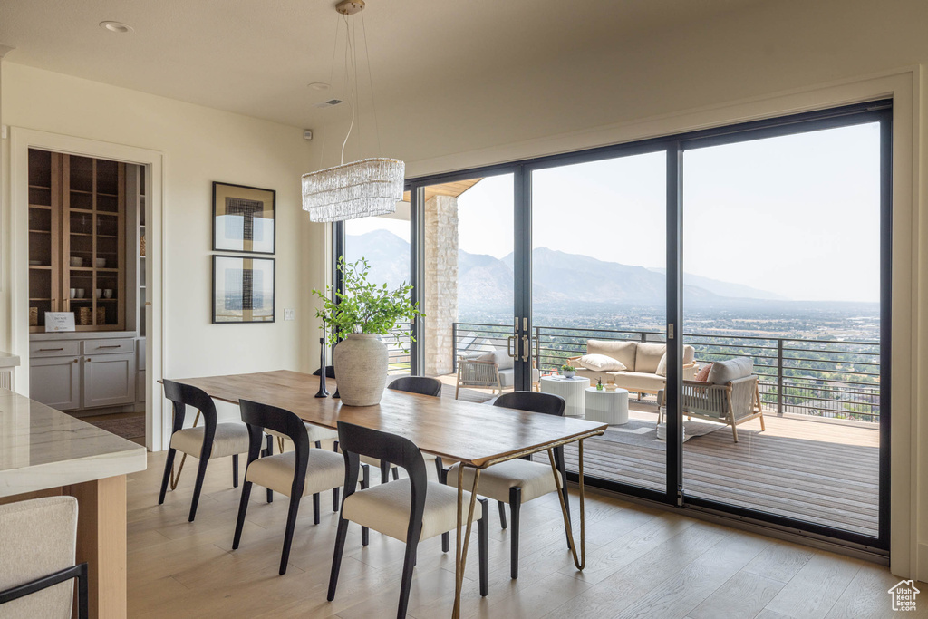 Dining space featuring a mountain view, a healthy amount of sunlight, and light hardwood / wood-style floors