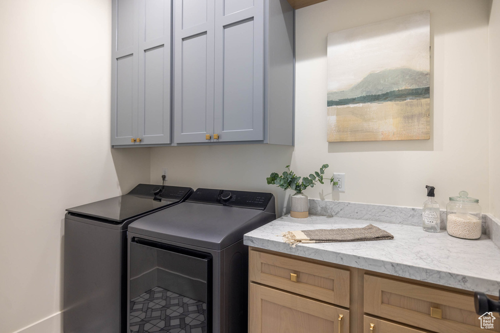 Laundry area featuring washing machine and dryer and cabinets