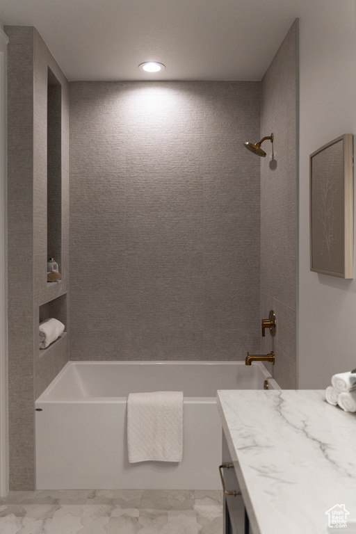 Bathroom featuring tiled shower / bath combo, vanity, and tile patterned floors