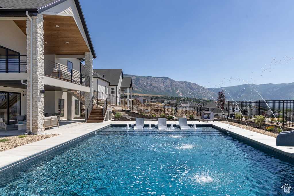 View of swimming pool with a mountain view and a patio area