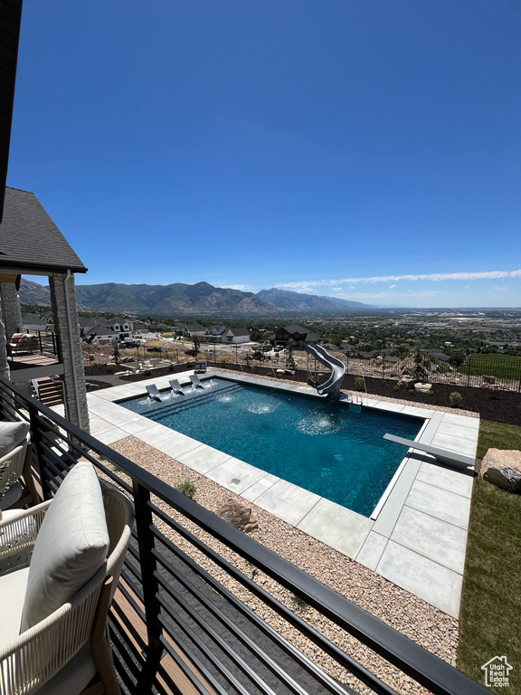 View of pool featuring a mountain view, a patio area, and a water slide