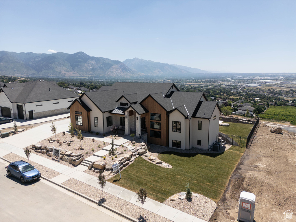 View of front of home with a mountain view and a front yard