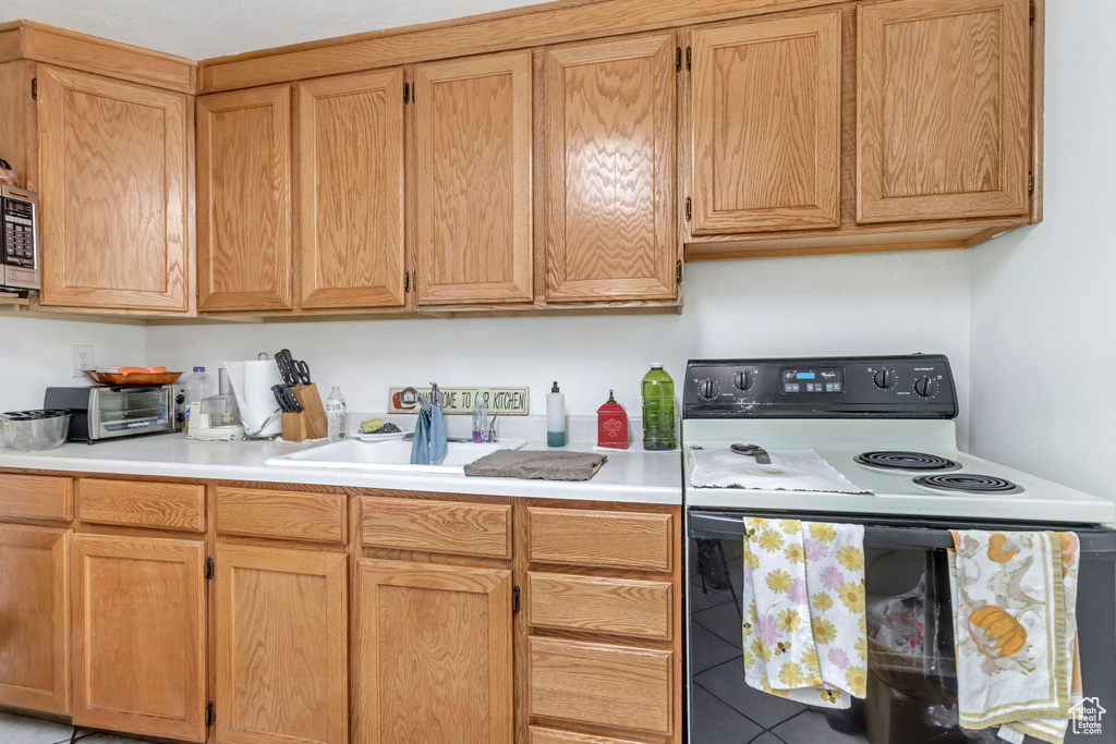 Kitchen featuring white electric range and stainless steel microwave