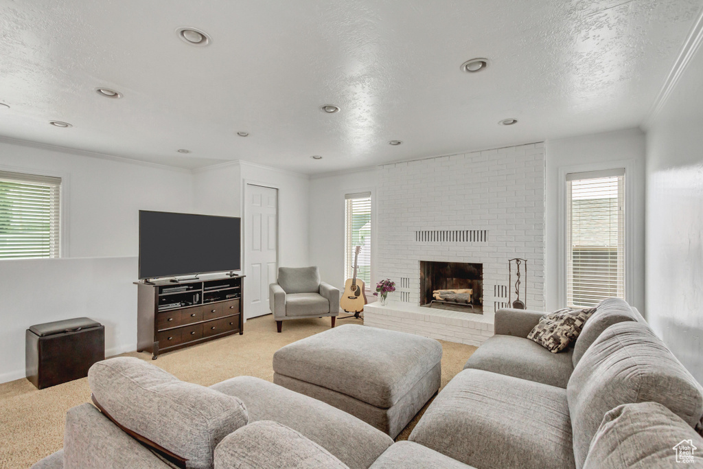 Carpeted living room featuring a brick fireplace and a textured ceiling