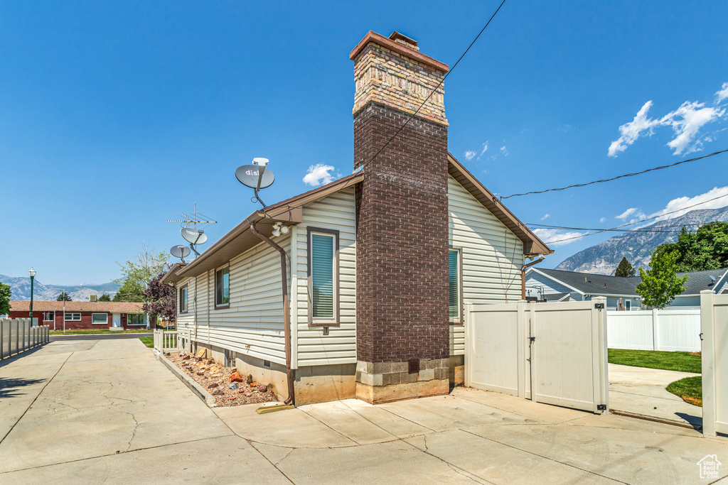 View of side of home with a patio area and a mountain view