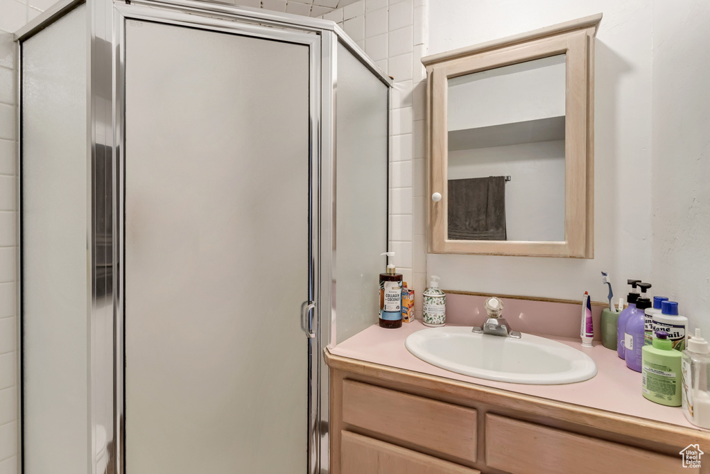 Bathroom featuring vanity and a shower with door