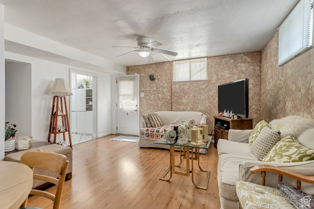 Living room with ceiling fan, hardwood / wood-style flooring, and a wealth of natural light