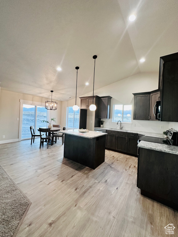 Kitchen featuring a kitchen island, light wood-type flooring, and a healthy amount of sunlight