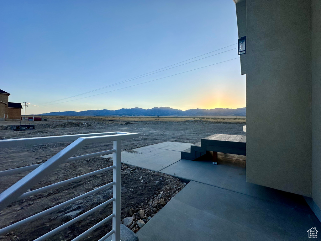 Patio terrace at dusk featuring a mountain view