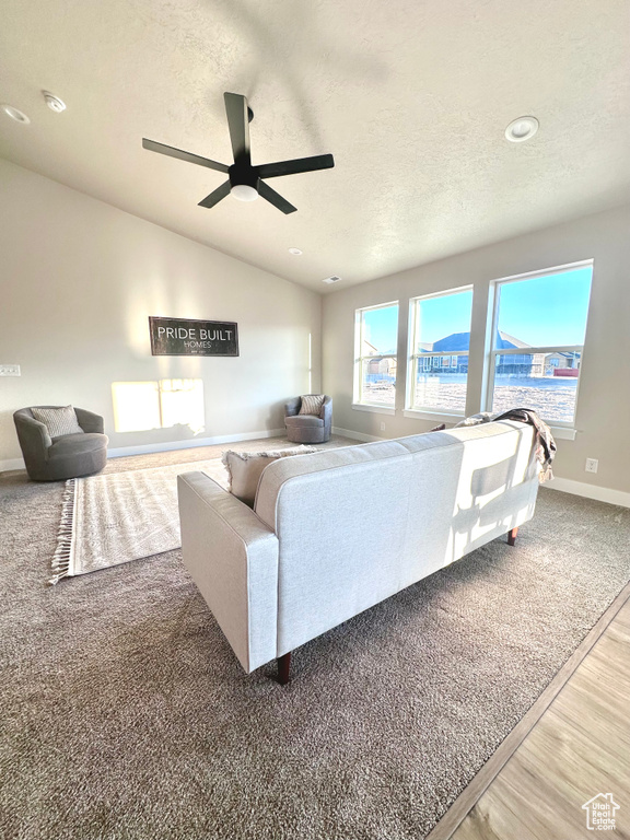 Living room with hardwood / wood-style floors, a textured ceiling, and ceiling fan