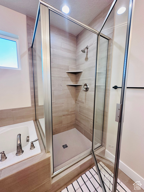 Bathroom featuring a textured ceiling, tile patterned floors, and separate shower and tub