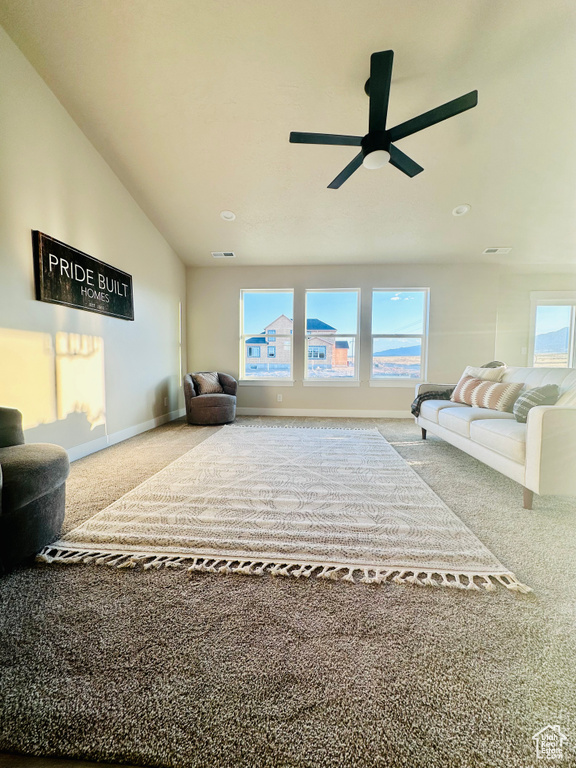 Carpeted living room featuring ceiling fan and lofted ceiling