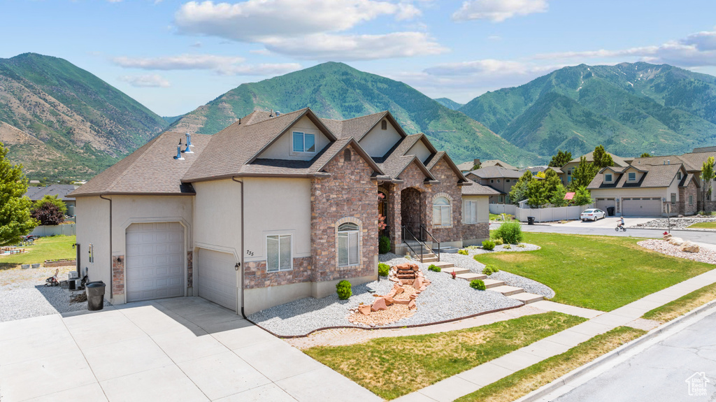 View of front of property featuring a garage and a mountain view