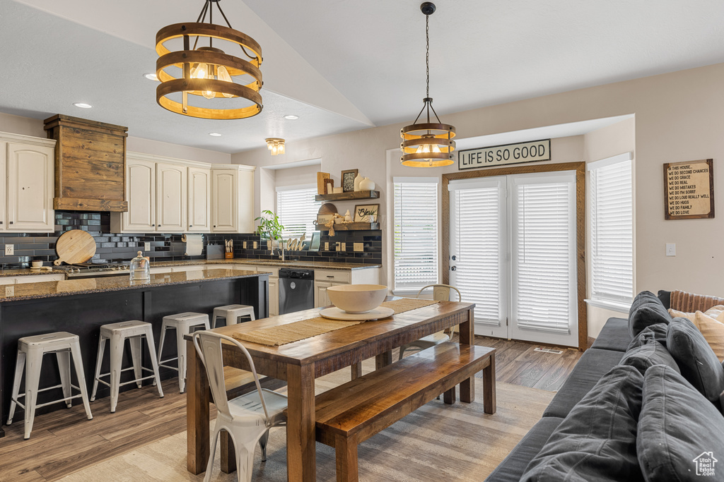 Dining room featuring light hardwood / wood-style floors, sink, and vaulted ceiling