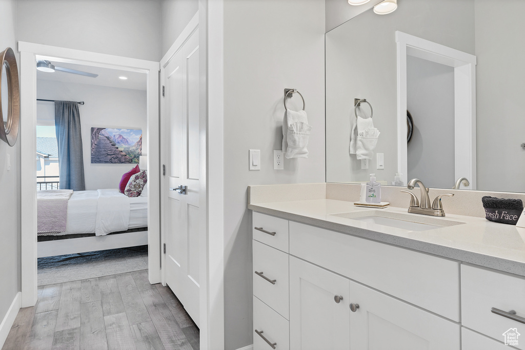 Bathroom featuring vanity, hardwood / wood-style flooring, and ceiling fan