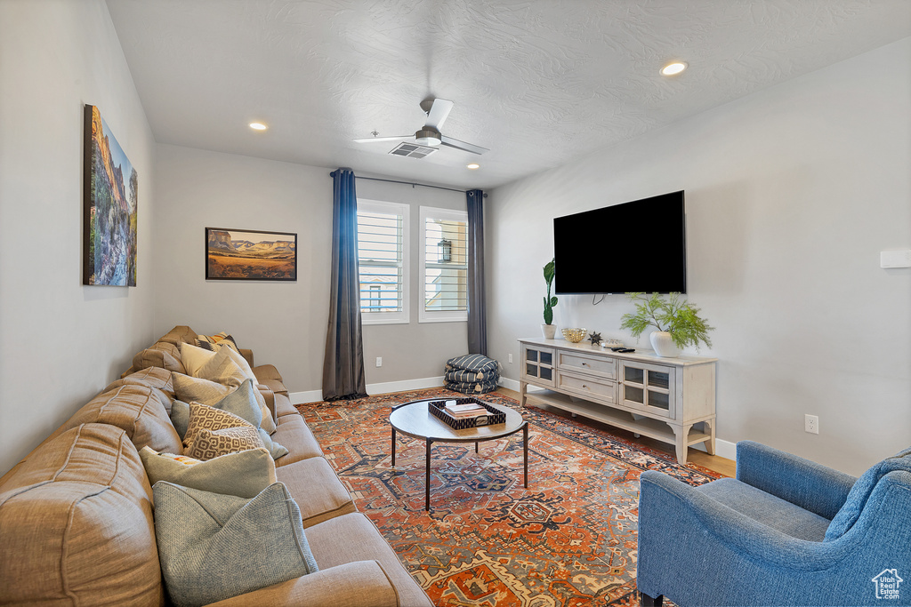 Living room featuring ceiling fan and hardwood / wood-style flooring