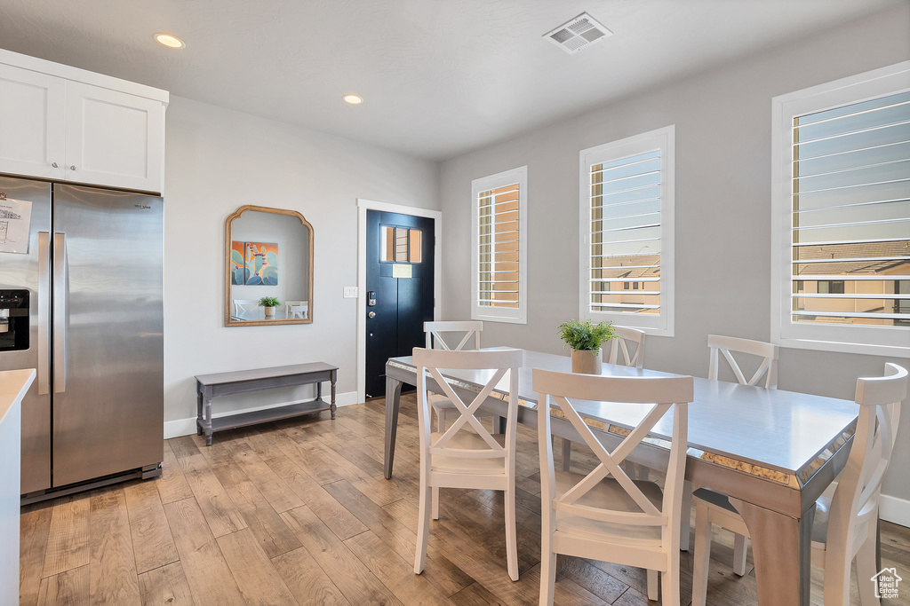 Dining space with light hardwood / wood-style floors and a wealth of natural light