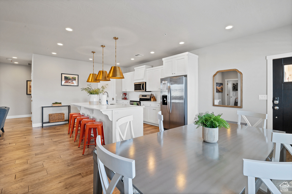 Dining area with sink and light wood-type flooring