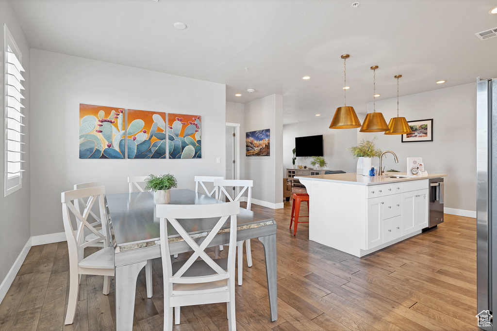 Dining space with sink and light hardwood / wood-style floors