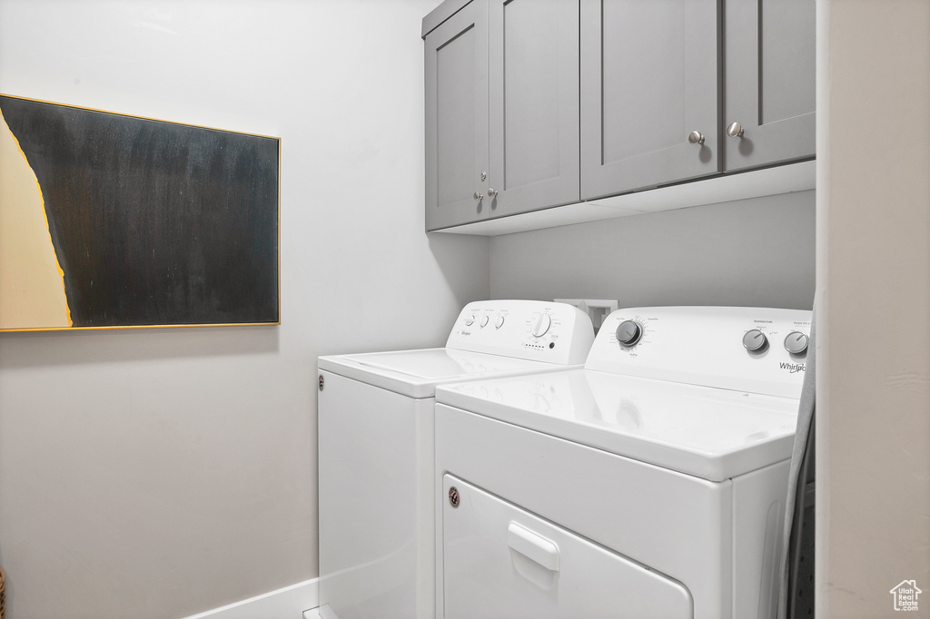 Clothes washing area with cabinets and washer and dryer