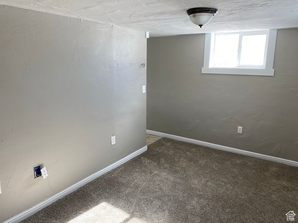 Carpeted empty room with a textured ceiling