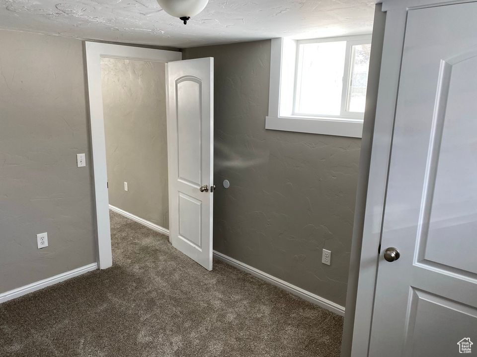 Carpeted spare room with a textured ceiling