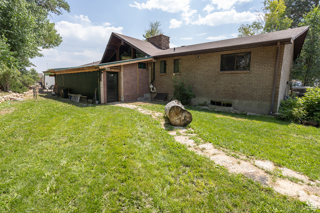 Rear view of house featuring a lawn