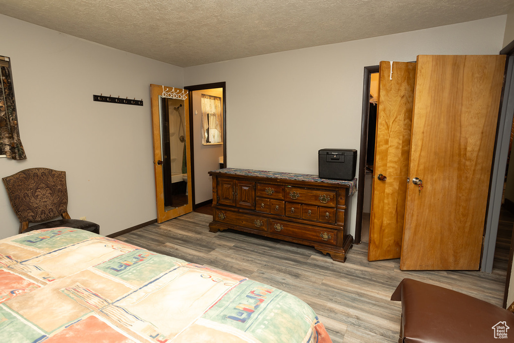 Bedroom featuring a textured ceiling and hardwood / wood-style floors