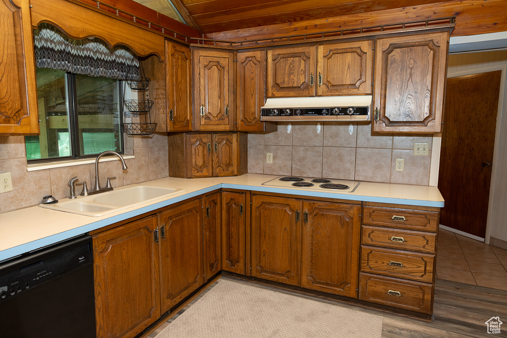 Kitchen with sink, white electric cooktop, dishwasher, and decorative backsplash