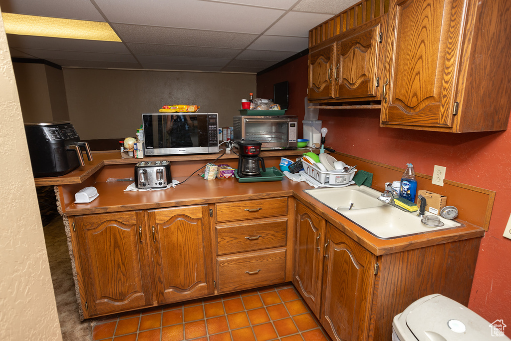 Kitchen with tile patterned floors and a paneled ceiling