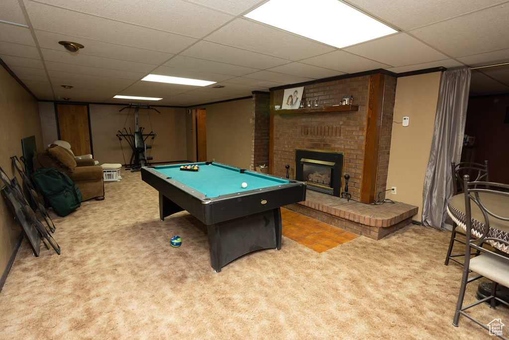 Recreation room with a drop ceiling, a fireplace, billiards, brick wall, and carpet floors