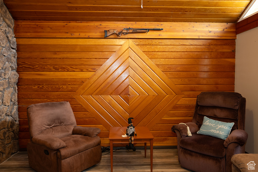 Sitting room featuring wooden walls, lofted ceiling, wood-type flooring, and wood ceiling