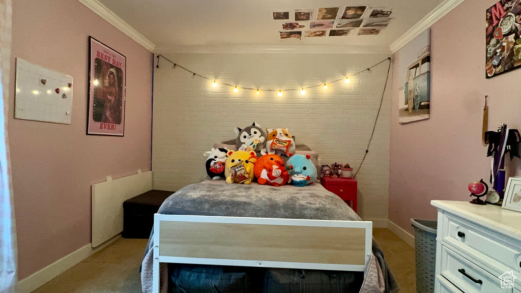 Bedroom with ornamental molding and brick wall