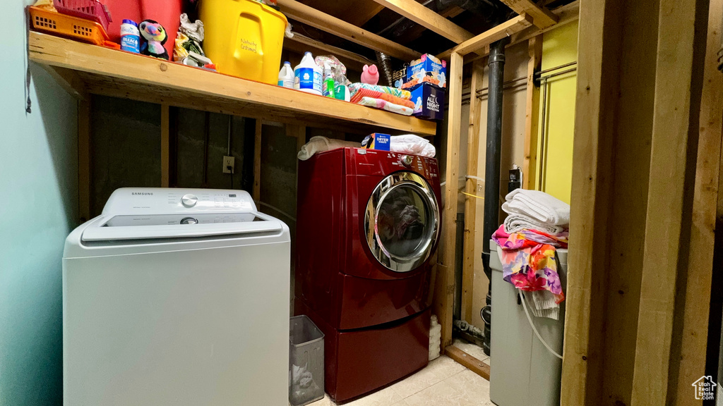 Laundry room with light tile patterned flooring and washer and dryer